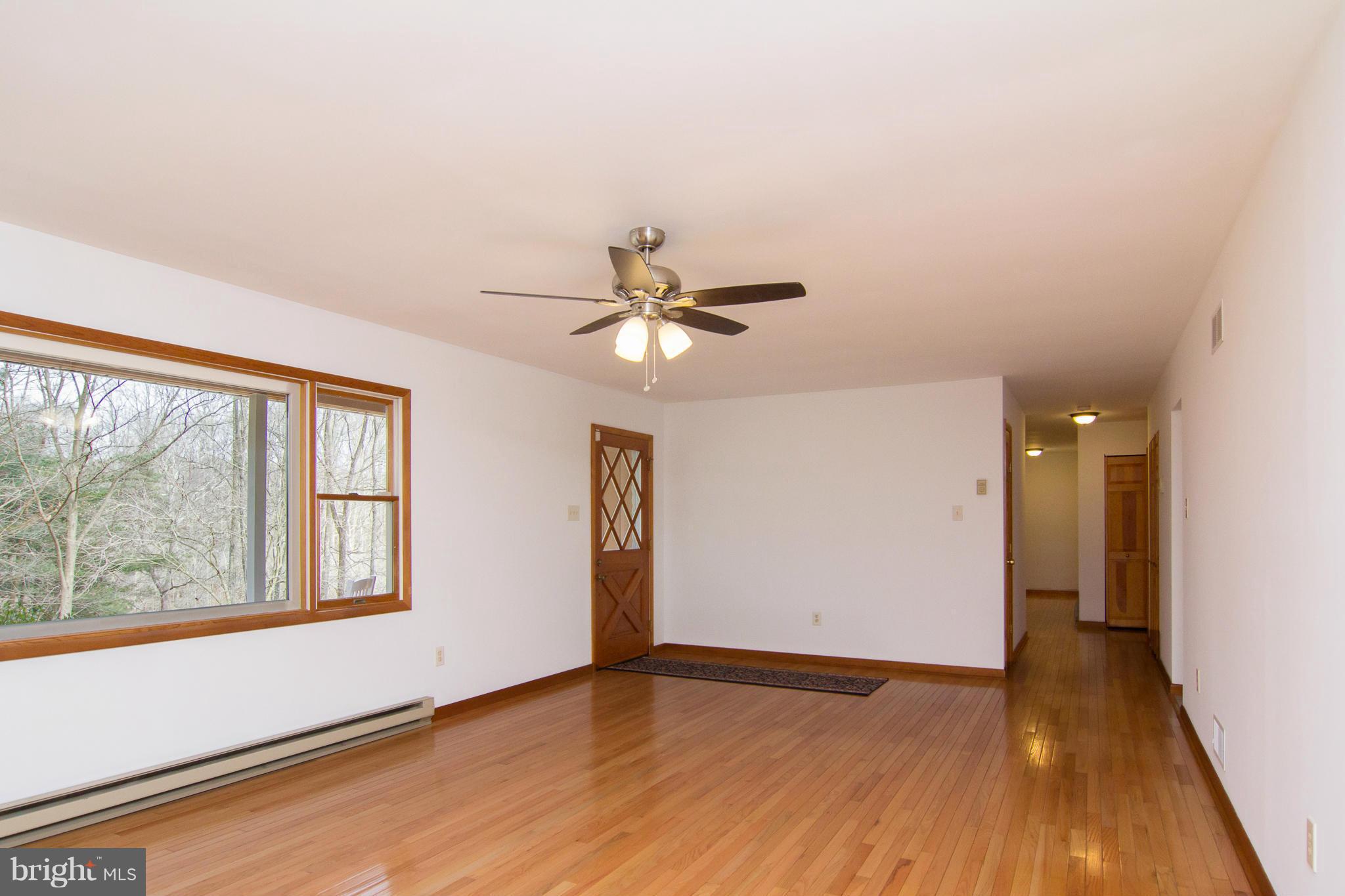 19306 Resh Mill Road Hampstead, MD 21074 - Photo 3 of 30 a view of empty room with wooden floor and fan