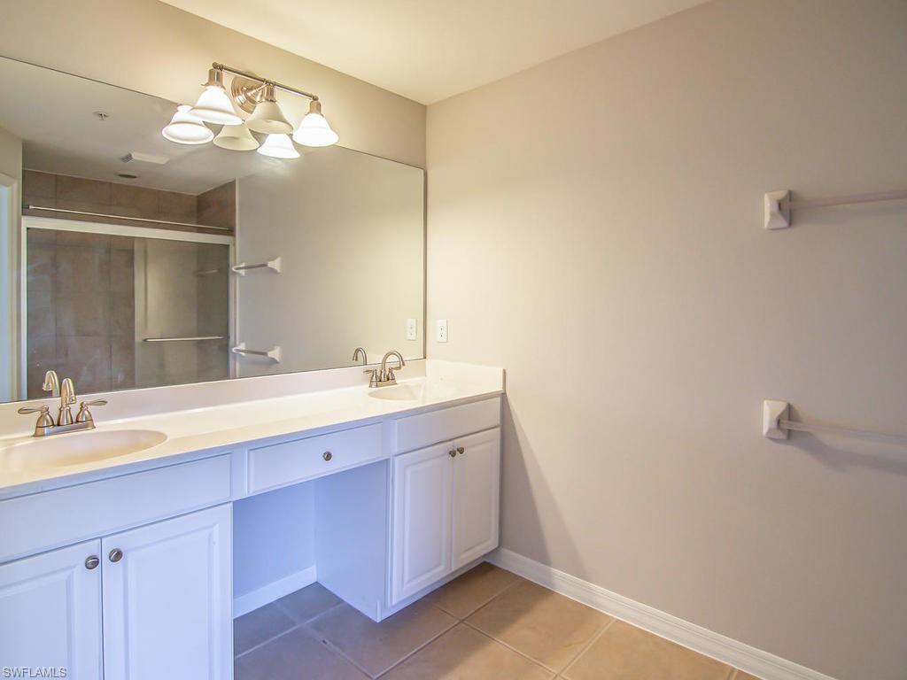16170 Caldera Lane, Unit 37 Naples, FL 34110 - Photo 12 of 23 a bathroom with a double vanity sink and a mirror