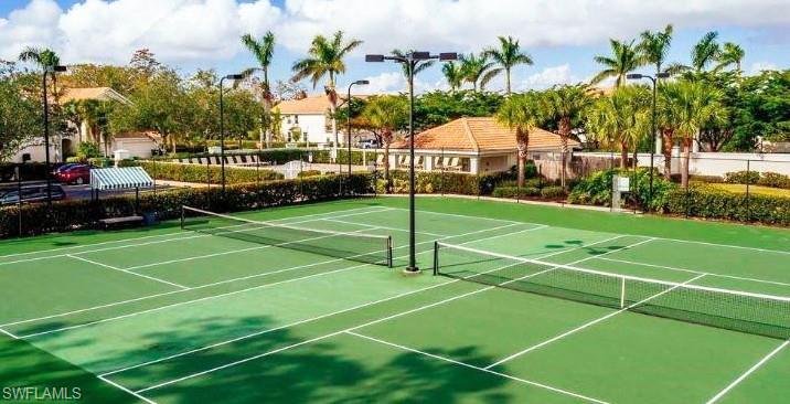 16170 Caldera Lane, Unit 37 Naples, FL 34110 - Photo 22 of 23 a view of a tennis ground with large trees