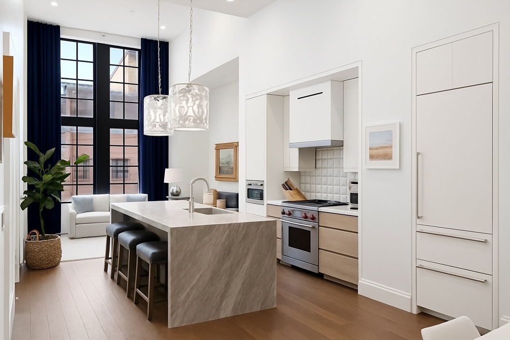 a kitchen with stainless steel appliances granite countertop a stove a sink dishwasher and a refrigerator with wooden floor