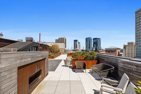 a view of roof deck with patio a barbeque grill with couches and potted plants