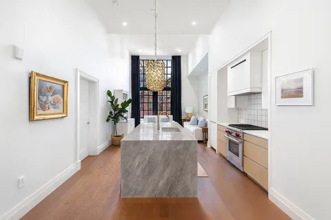 a large kitchen with cabinets a stove and a wooden floor