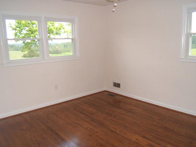 1161 Blankenship Road Goodview, VA 24095 - Photo 7 of 12 an empty room with wooden floor and windows
