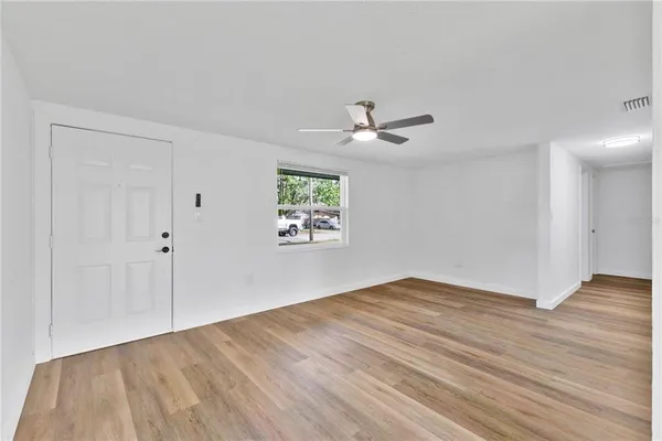 a view of empty room with wooden floor