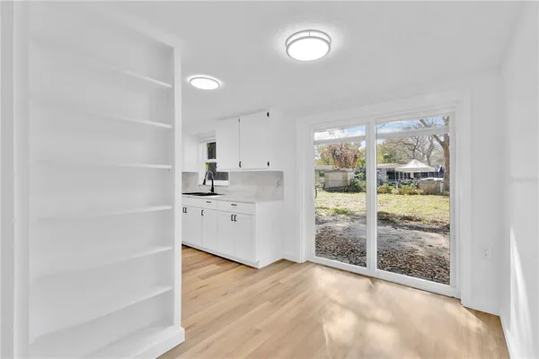 a view of a kitchen with wooden floor and a window