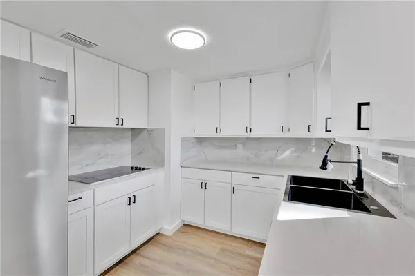 a kitchen with granite countertop white cabinets and white appliances
