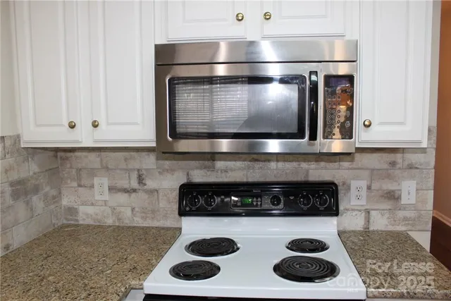 a kitchen with granite countertop cabinets and wooden floor
