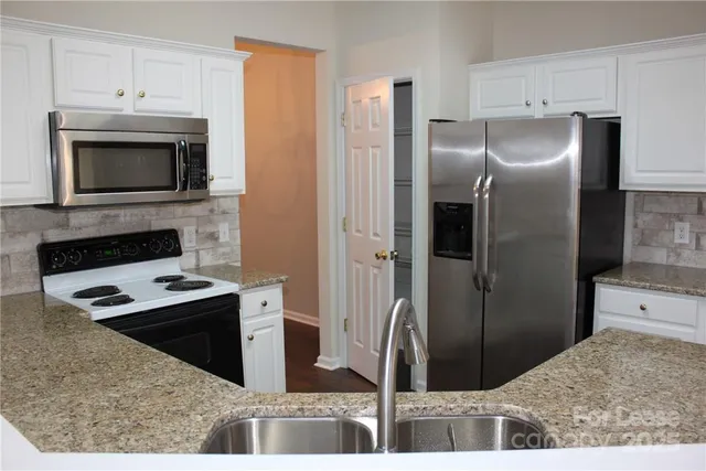 a kitchen with granite countertop a sink and a stove