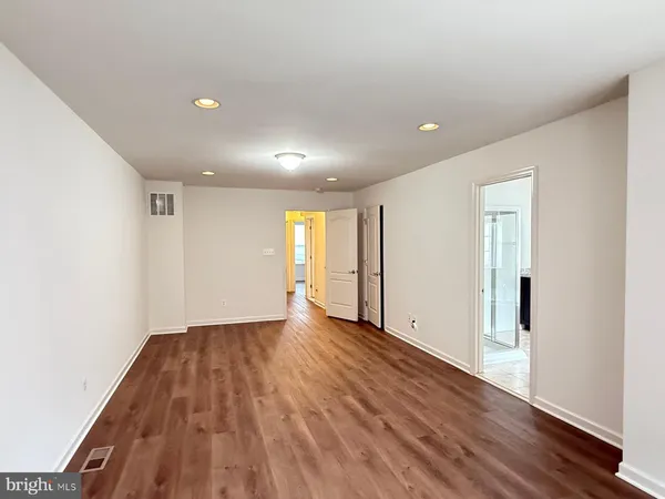 a view of an empty room with wooden floor