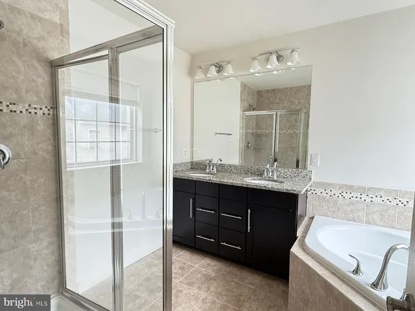 a bathroom with a tub sink and mirror