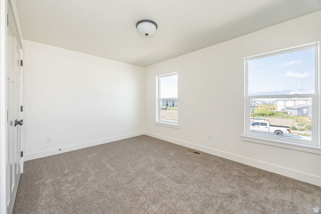 3308 South 1000 West Logan, UT 84321 - Photo 16 of 30 Plush carpet flooring, white painted walls, two windows, and an overhead flush mount light fixture