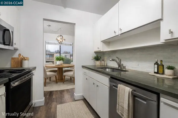 a kitchen with granite countertop a sink a stove and cabinets