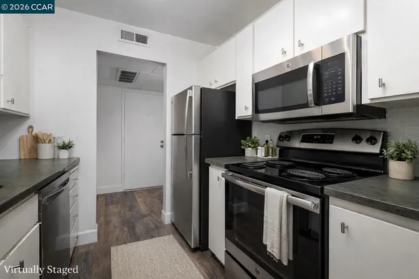 a kitchen with stainless steel appliances granite countertop a stove microwave and refrigerator