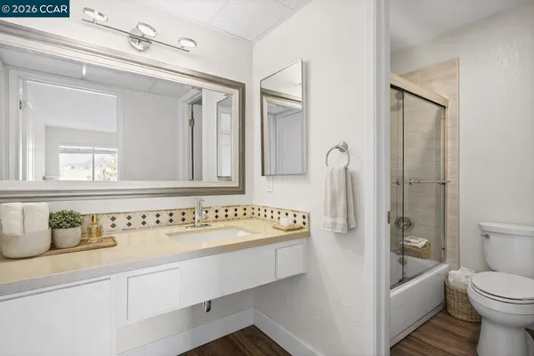 a bathroom with a sink a toilet and a mirror