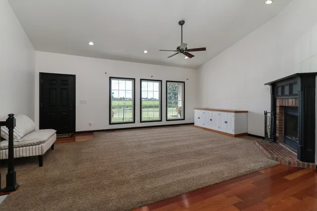 a view of an empty room with a fireplace and a window