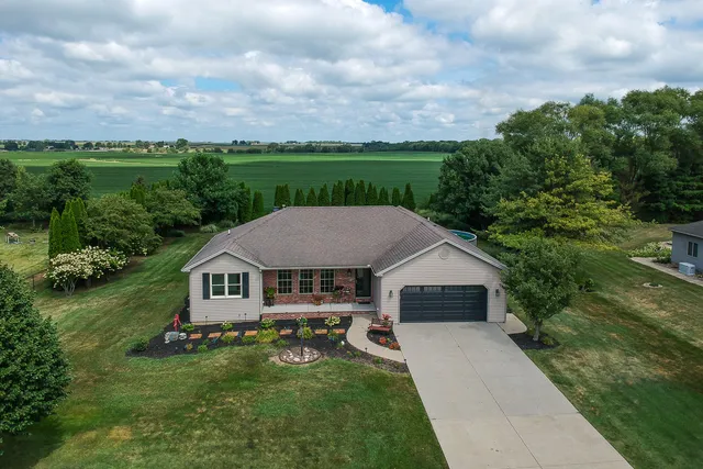 a aerial view of a house with yard and green space