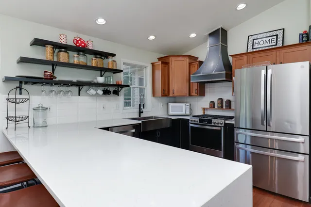 a kitchen with stainless steel appliances granite countertop a sink and a refrigerator