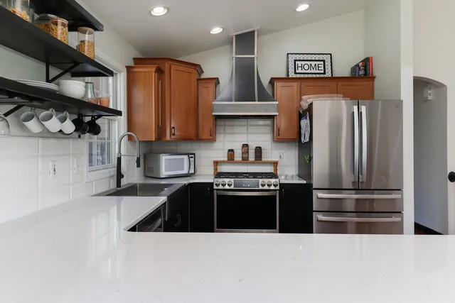 an empty room with chandelier fan and windows
