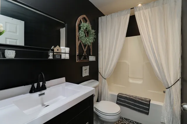a bathroom with a toilet sink and mirror