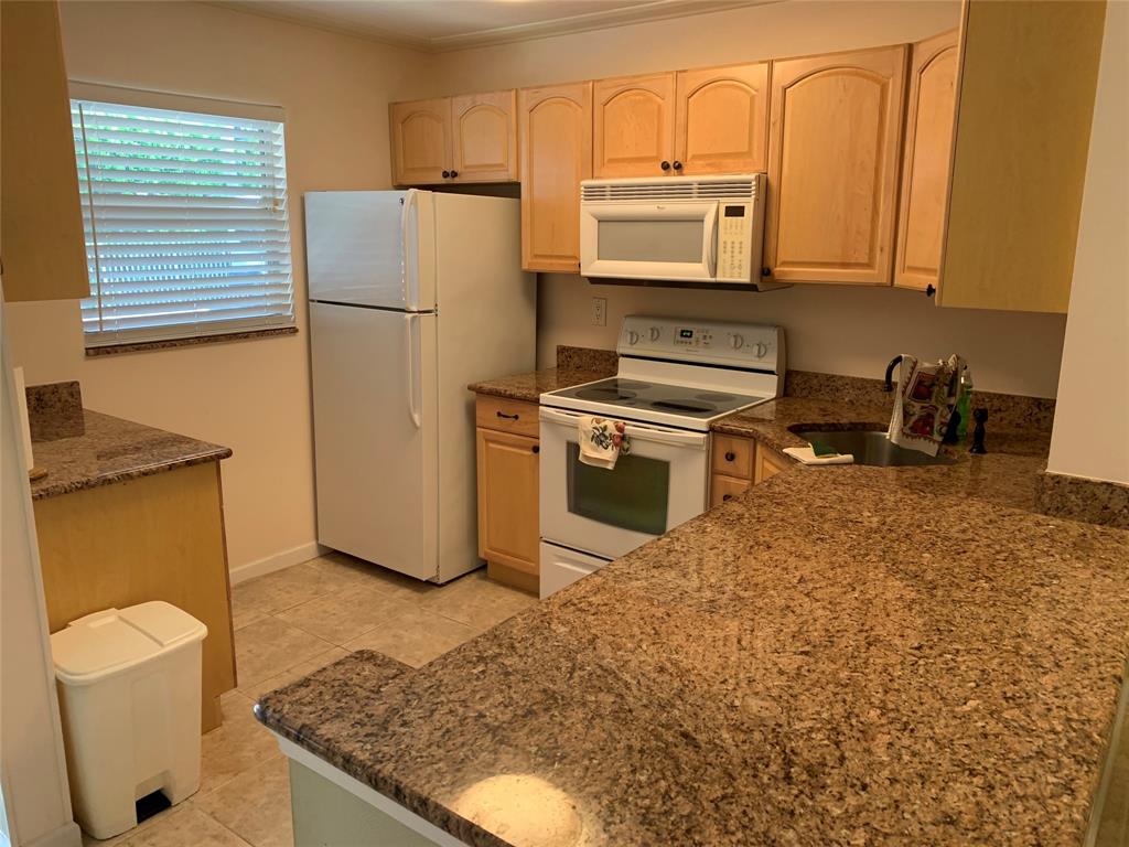 1541 South Ocean Boulevard, Unit 122 Pompano Beach, FL 33062 - Photo 4 of 30 a kitchen with stainless steel appliances granite countertop a refrigerator sink and stove