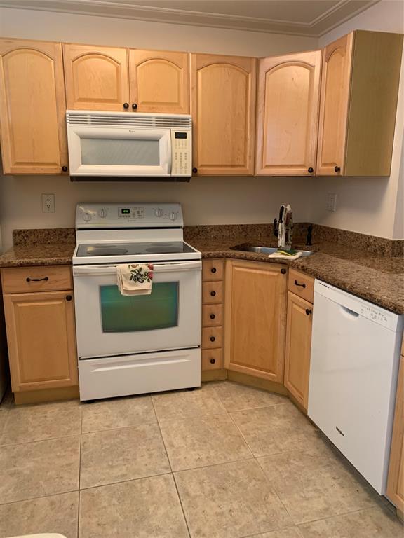 1541 South Ocean Boulevard, Unit 122 Pompano Beach, FL 33062 - Photo 6 of 30 a kitchen with granite countertop white cabinets and appliances