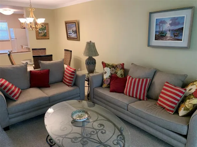 a living room with furniture and a chandelier