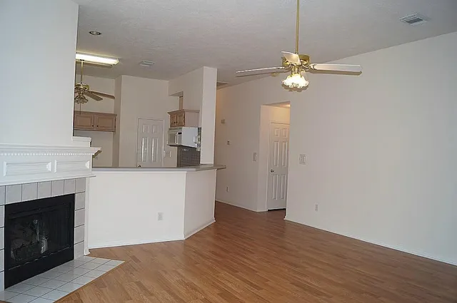 a view of a room with wooden floor and a fireplace