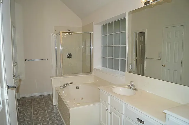 a bathroom with a tub sink and mirror