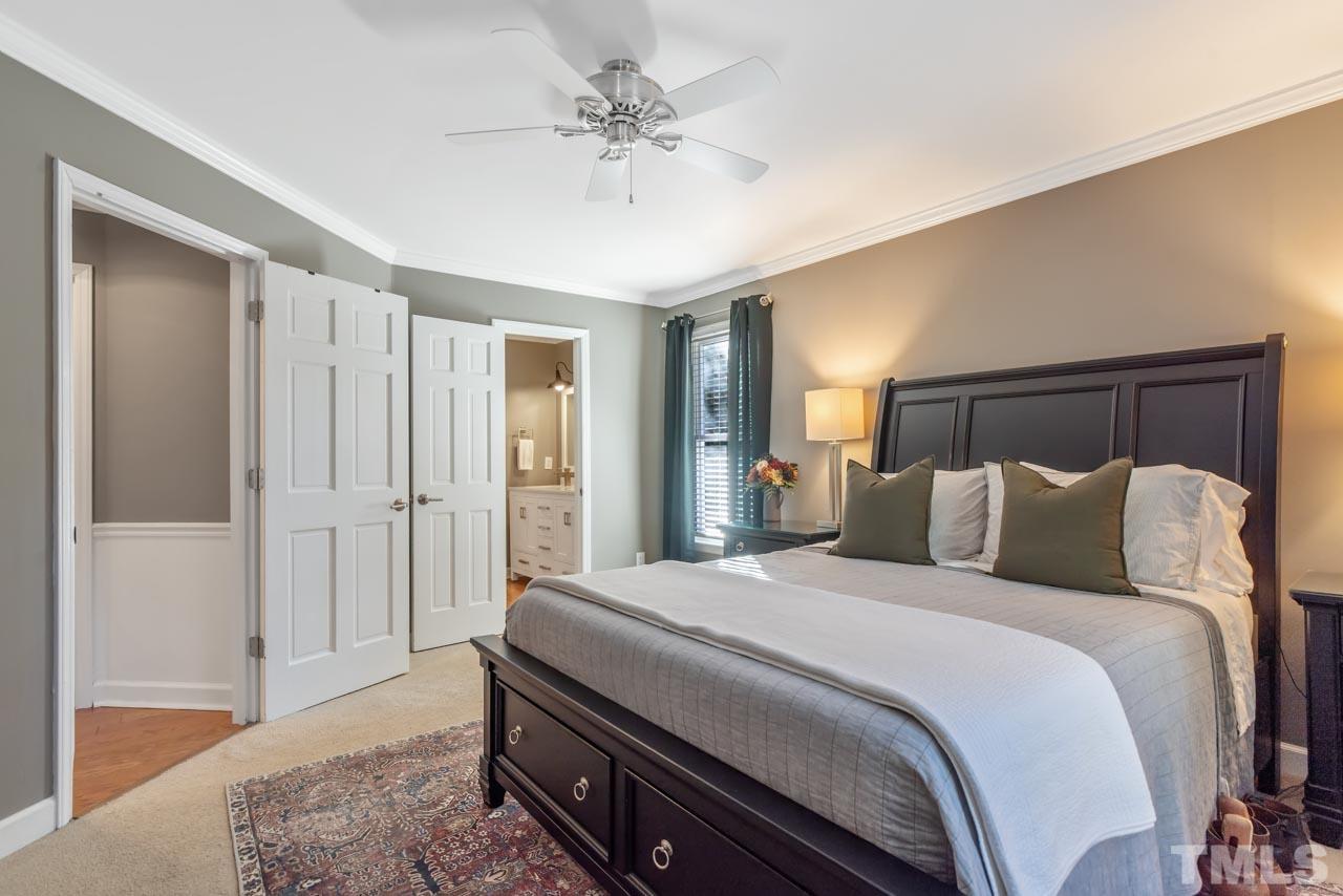 4309 Pleasant Grove Church Road Raleigh, NC 27613 - Photo 11 of 29 a spacious bedroom with a bed and a chandelier