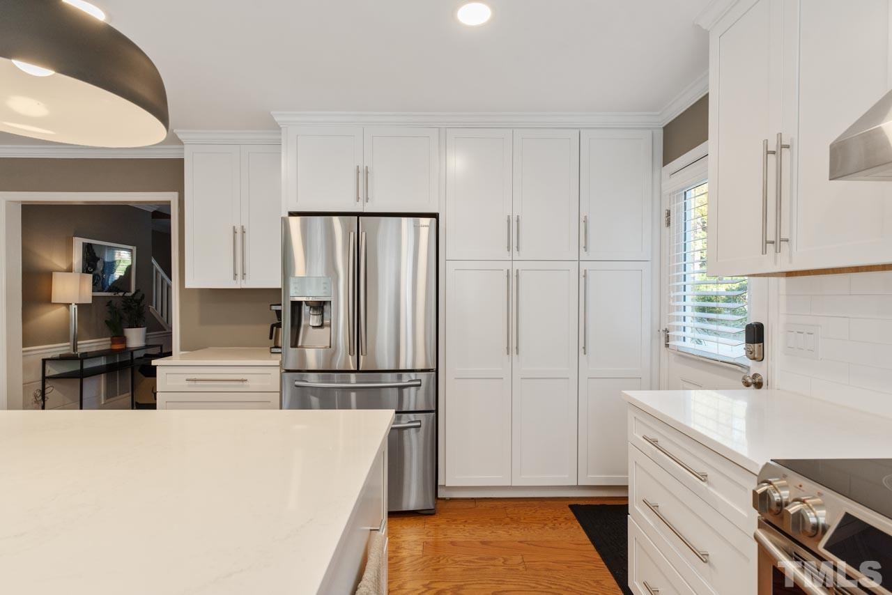 4309 Pleasant Grove Church Road Raleigh, NC 27613 - Photo 17 of 29 a kitchen with kitchen island white cabinets and stainless steel appliances