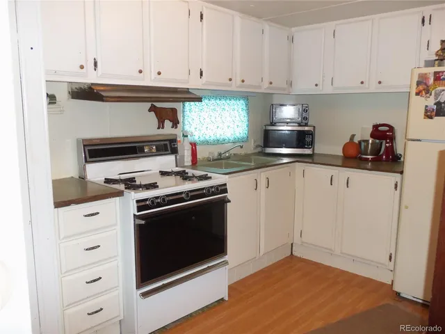 a kitchen with granite countertop white cabinets and stainless steel appliances