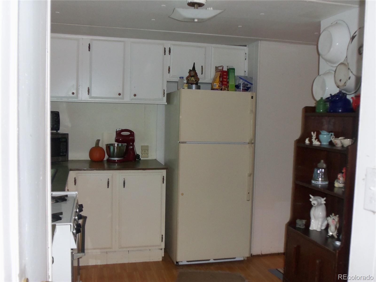 709 5th Street Hugo, CO 80821 - Photo 3 of 9 a kitchen with a refrigerator and cabinets