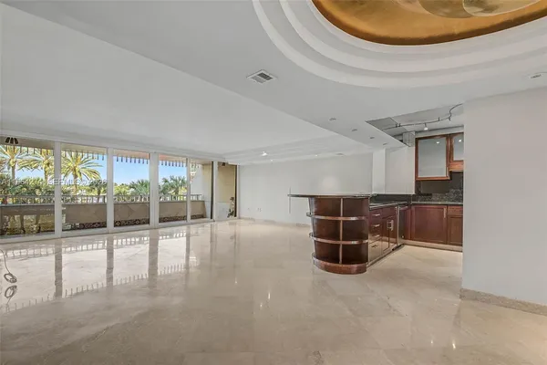an empty room with floor to ceiling window and ceiling fan