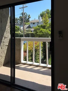 a view of a room with a large window and front door