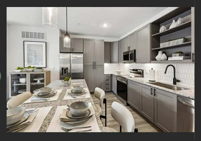 a kitchen with stainless steel appliances kitchen island granite countertop a sink and cabinets