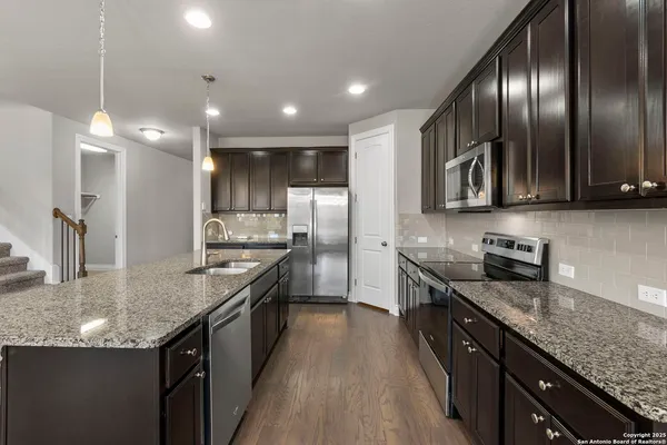 a kitchen with granite countertop stainless steel appliances and wooden cabinets