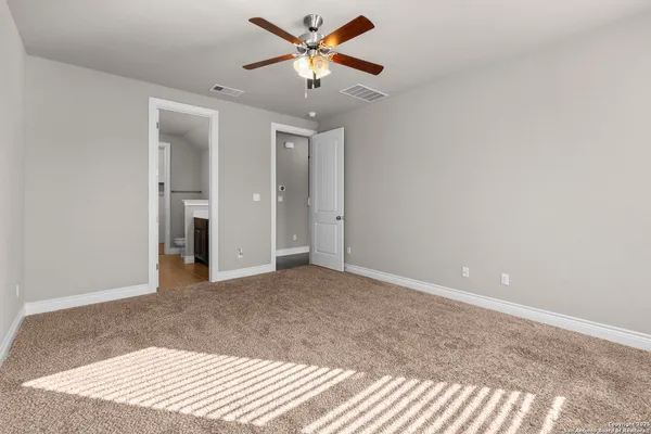 a view of a room with a ceiling fan and a window