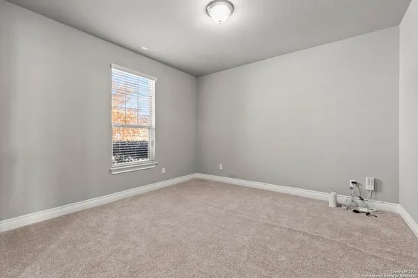an empty room with a white wall and a window