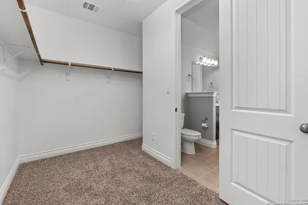 a bathroom with a granite countertop sink and a toilet