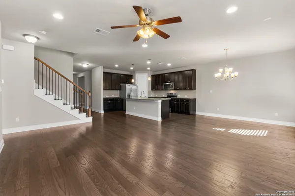 a view of a kitchen with a stove cabinets wooden floor and a chandelier