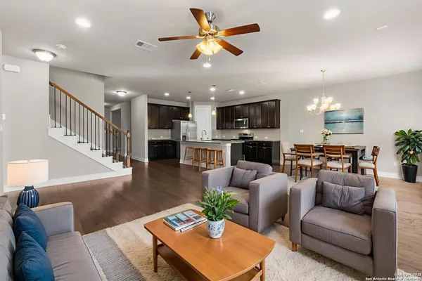 a living room with furniture kitchen view and a chandelier