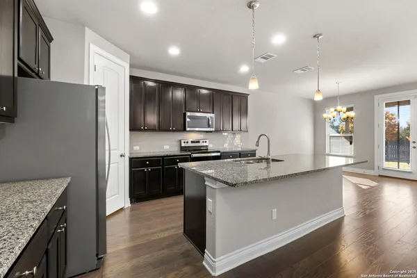 a kitchen with stainless steel appliances granite countertop a sink stove and refrigerator