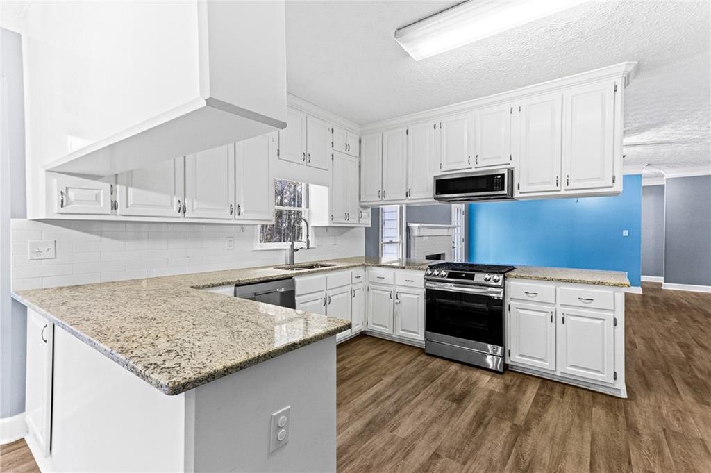 1394 Maple Drive Southwest Lilburn, GA 30047 - Photo 11 of 31 a kitchen with granite countertop a sink stove and refrigerator