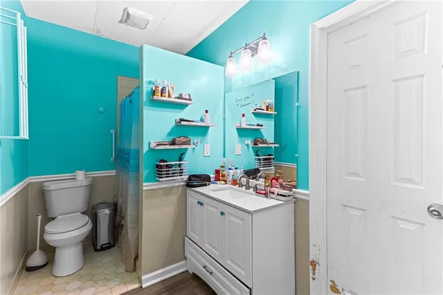 a bathroom with a toilet sink vanity and mirror