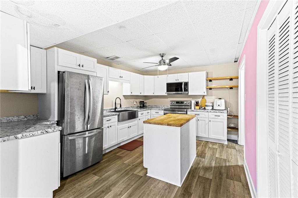 1394 Maple Drive Southwest Lilburn, GA 30047 - Photo 25 of 31 a kitchen with refrigerator cabinets and wooden floor