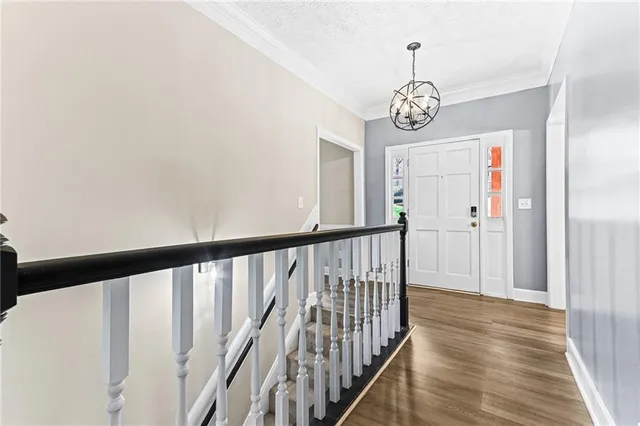 a view of a hallway with wooden floor and stairs