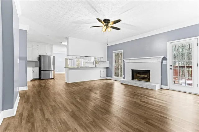 a view of a kitchen with a ceiling fan wooden floor and a kitchen