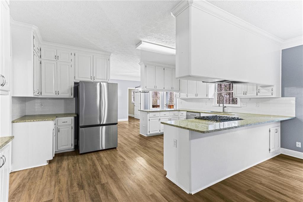 1394 Maple Drive Southwest Lilburn, GA 30047 - Photo 10 of 31 a kitchen with stainless steel appliances granite countertop a refrigerator a stove and a wooden floors