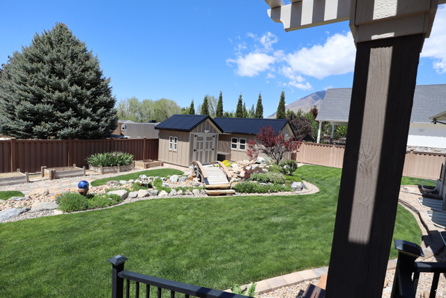 1055 North 1000 East Mapleton, UT 84664 - Photo 74 of 112 Expansive green lawn with a dedicated garden shed featuring a dark metal roof