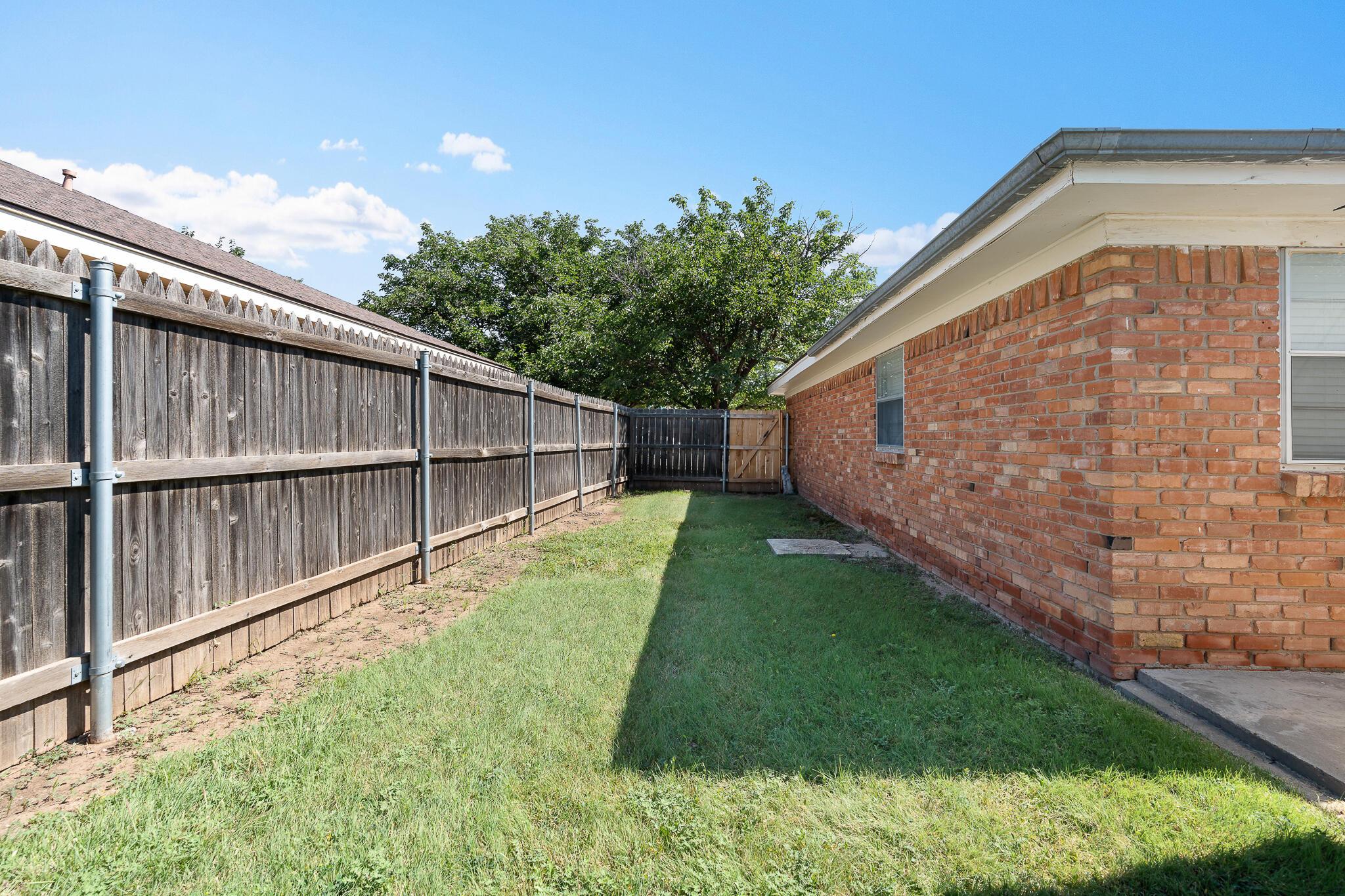 4803 Carole Lane Amarillo, TX 79110 - Photo 22 of 23 a backyard with wooden fence and a bench